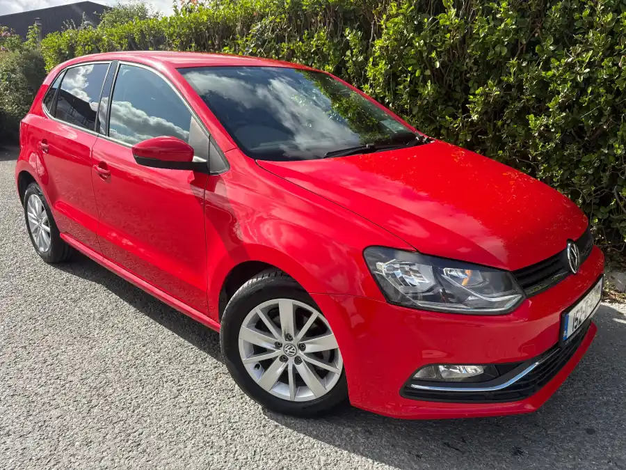 Red Volkswagen Polo, front view with the hedge behind, at RS Motors, Clonakilty